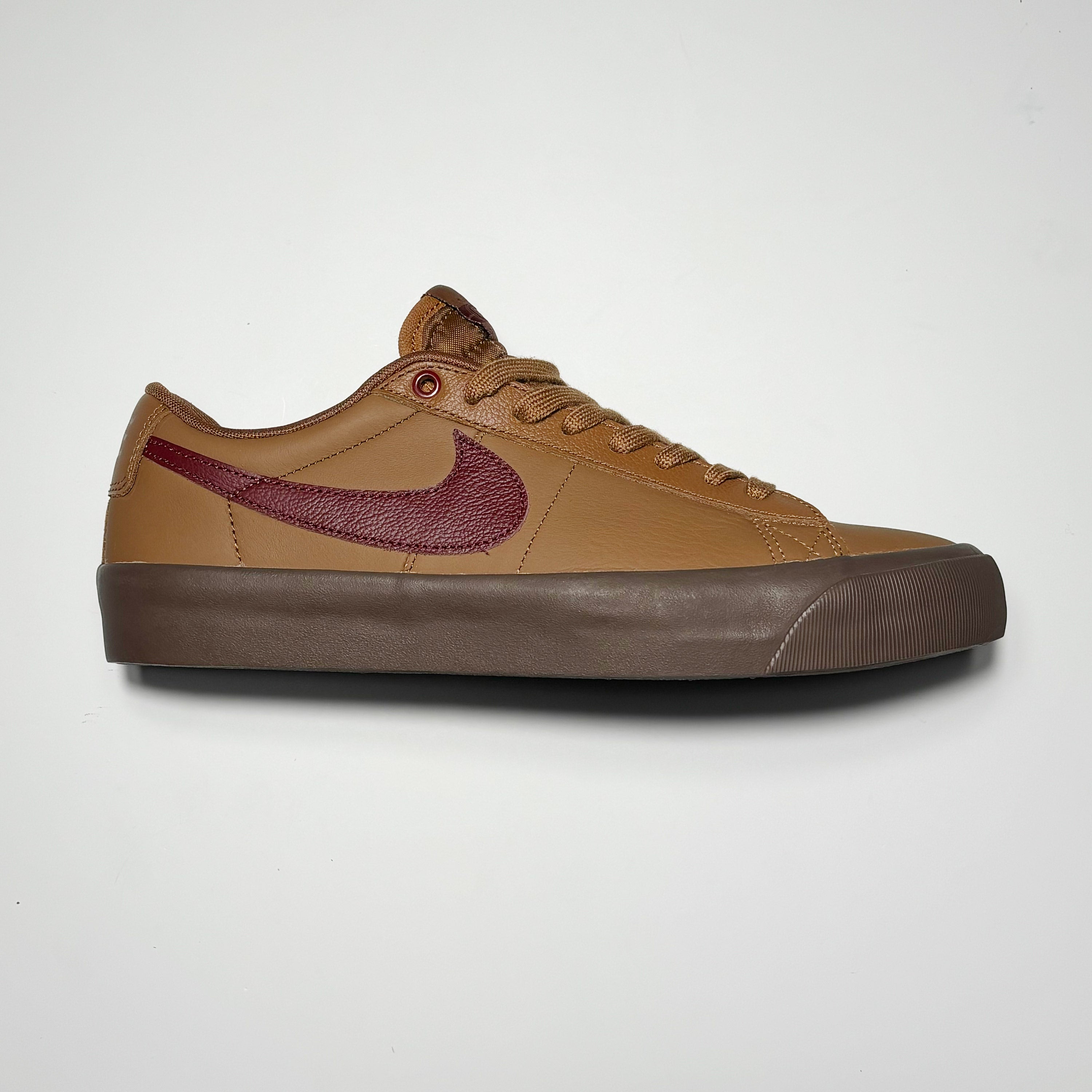Side image of right shoe. Tan leather with maroon nike swoosh. Gum outsole