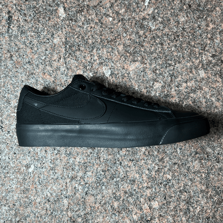 SIDE VIEW OF THE GRANT TAYLOR PRO MODEL SHOE FOR NIKE SB IN BLACK LEATHER AND CANVAS WITH BLACK SOLE DISPLAYED ON GRANITE