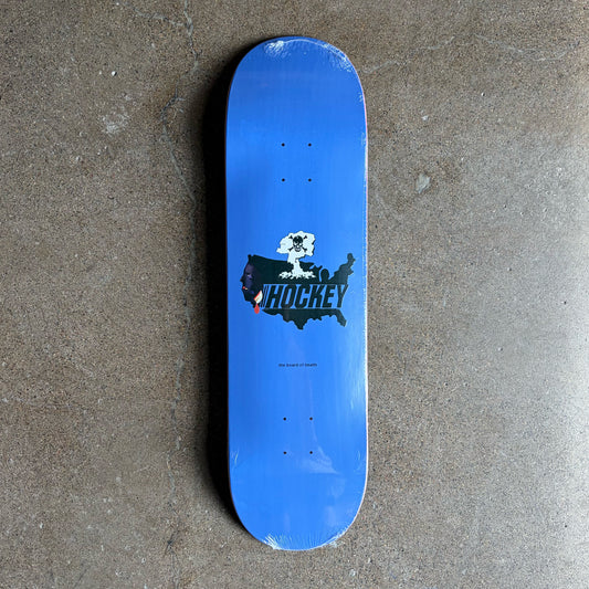 A blue skateboard deck with a black, white, and red 'HOCKEY' graphic on the underside, photographed from directly above on a textured gray concrete floor.