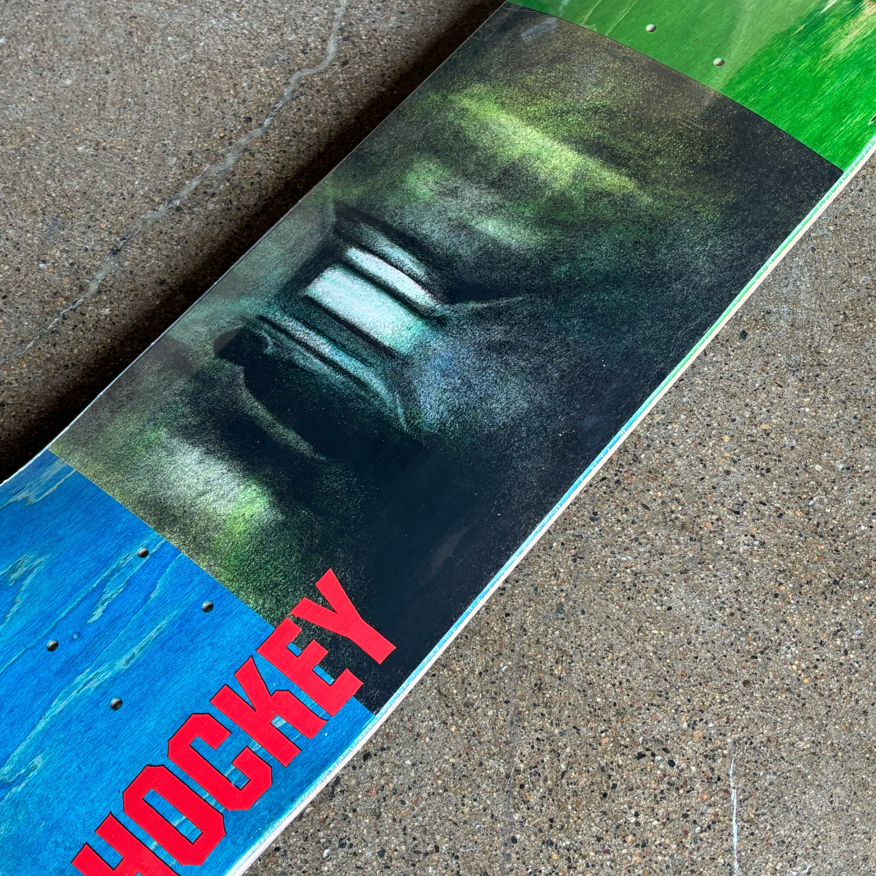 Close-up of a skateboard with 'Hockey' branding on a concrete surface