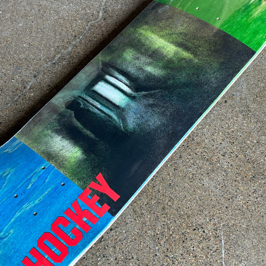 Close-up of a skateboard with 'Hockey' branding on a concrete surface
