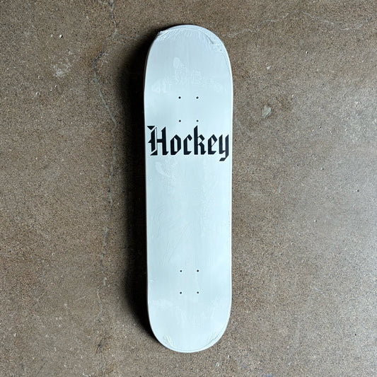 Full image of Hockey skateboard deck. White with hockey text in black on concrete floor