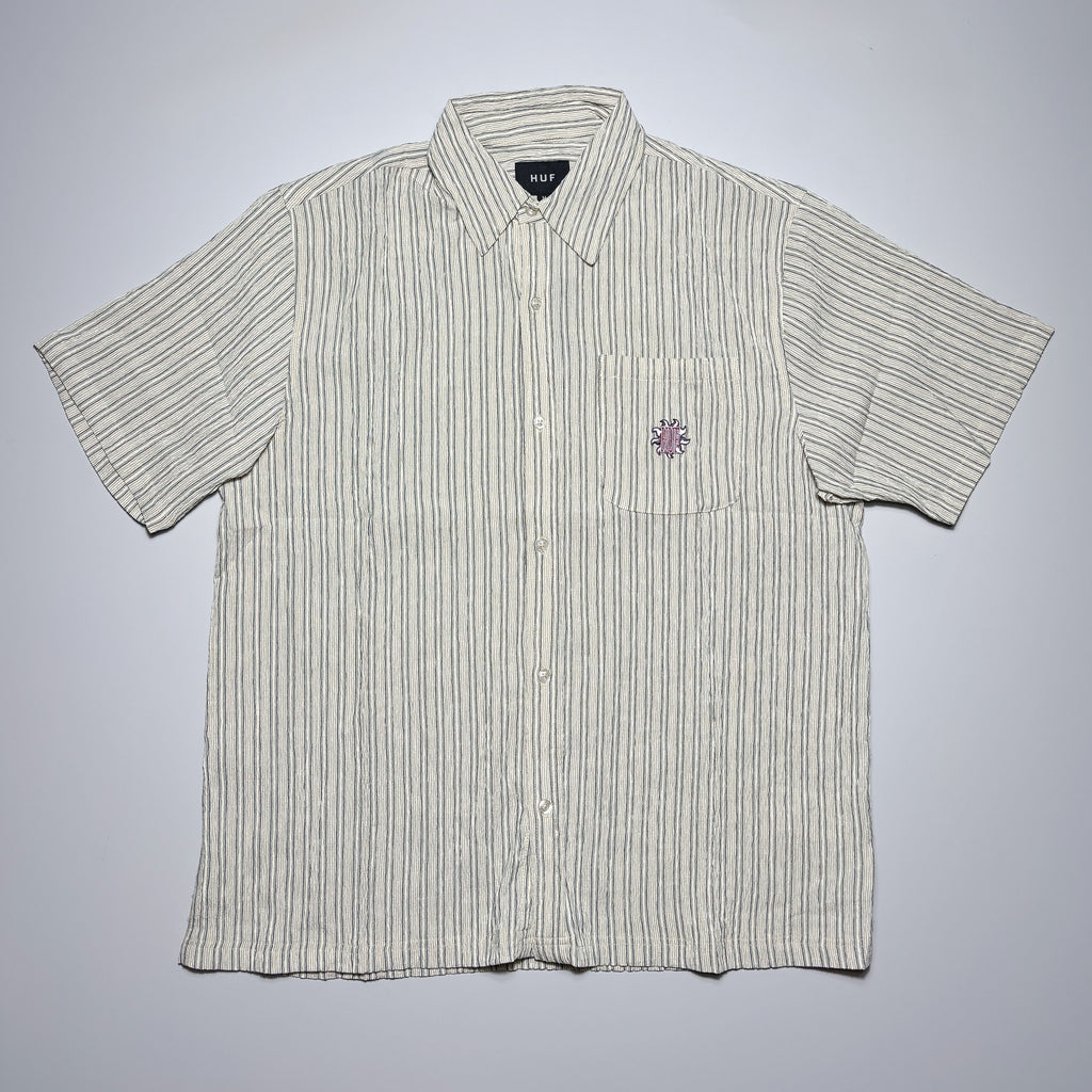 Front image of woven button up with logo embroidered on chest.
