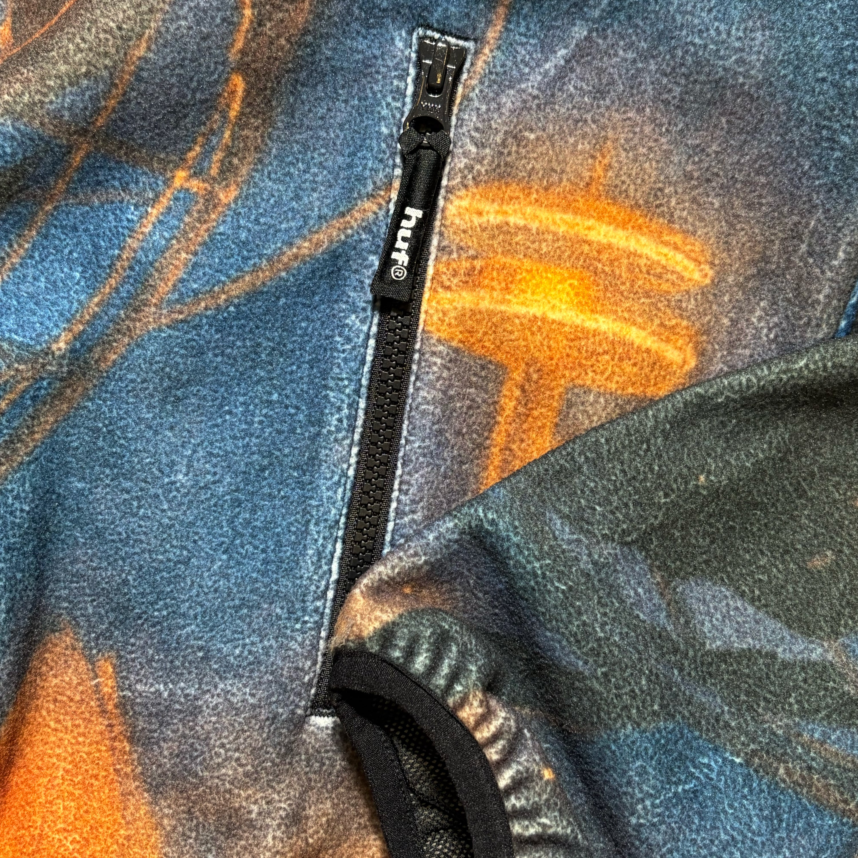 Close detail, custom HUF branded zipper pulls and cuffed opening.