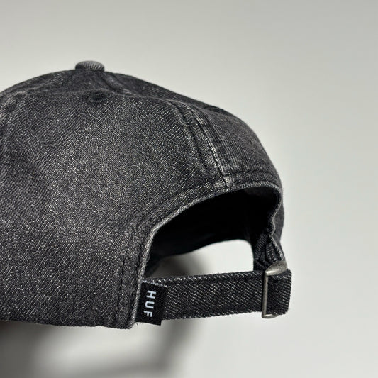 Back detail of black denim cap with HUF label on back.