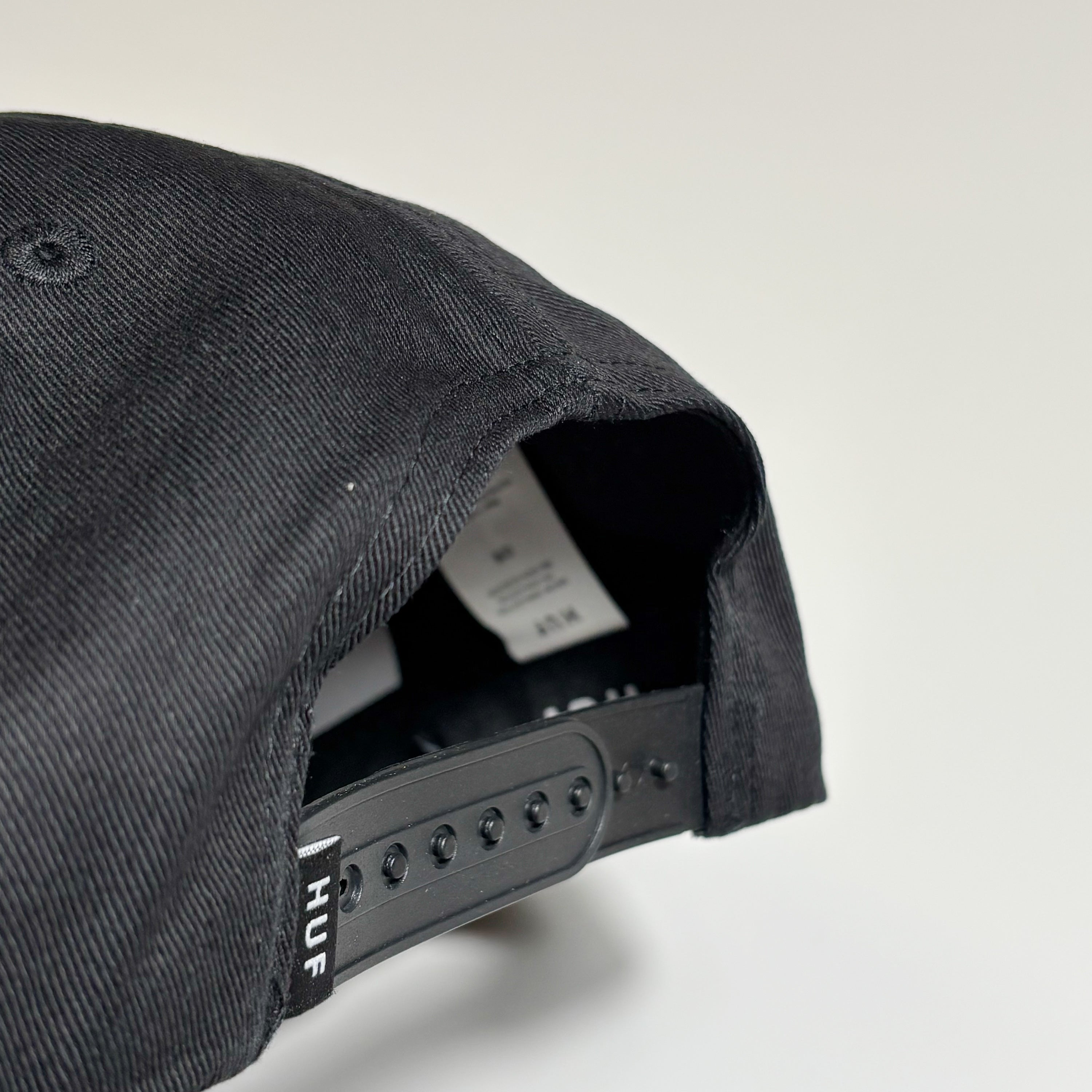 Snapback closure detail with woven label.