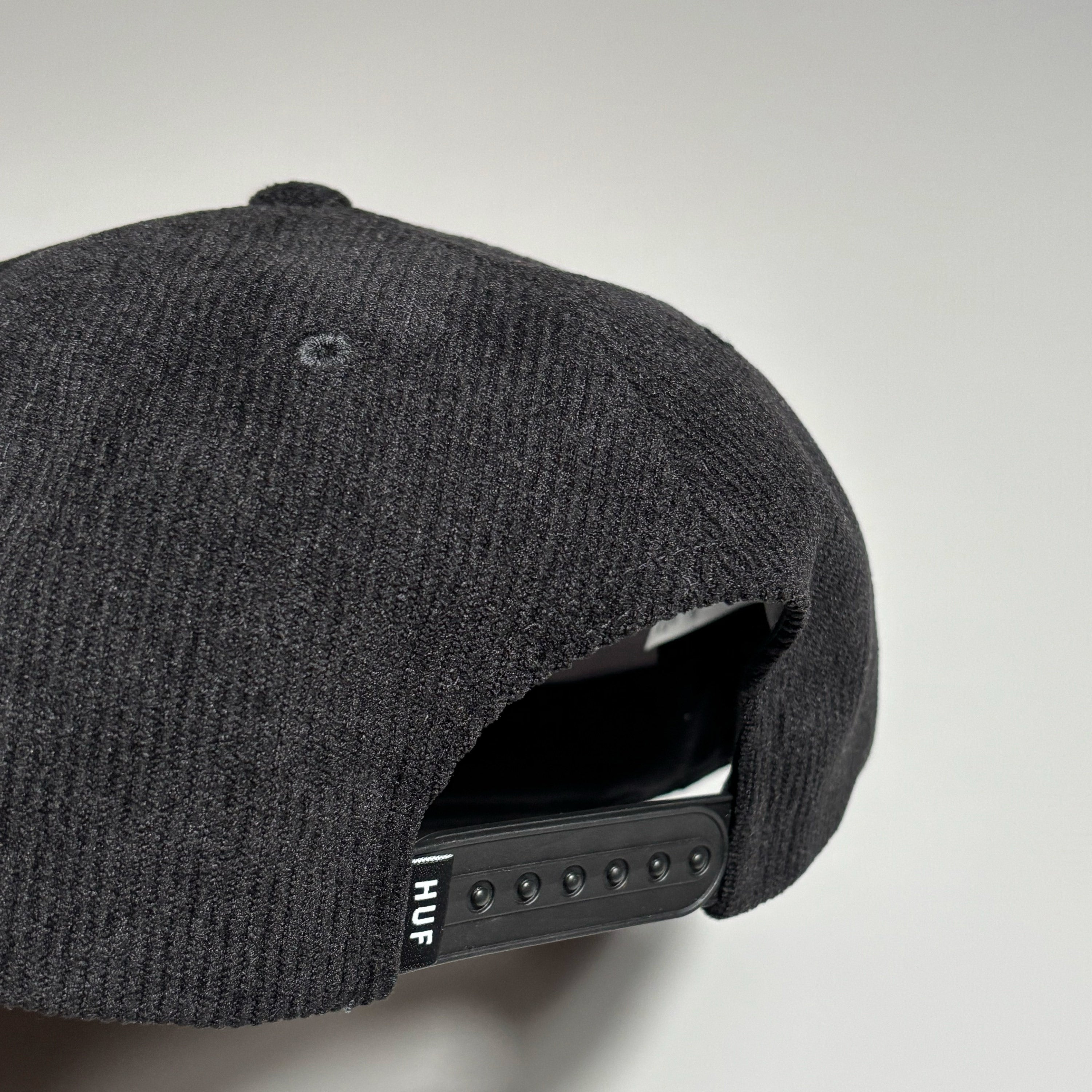 Back detail of black cord cap with HUF label on back.