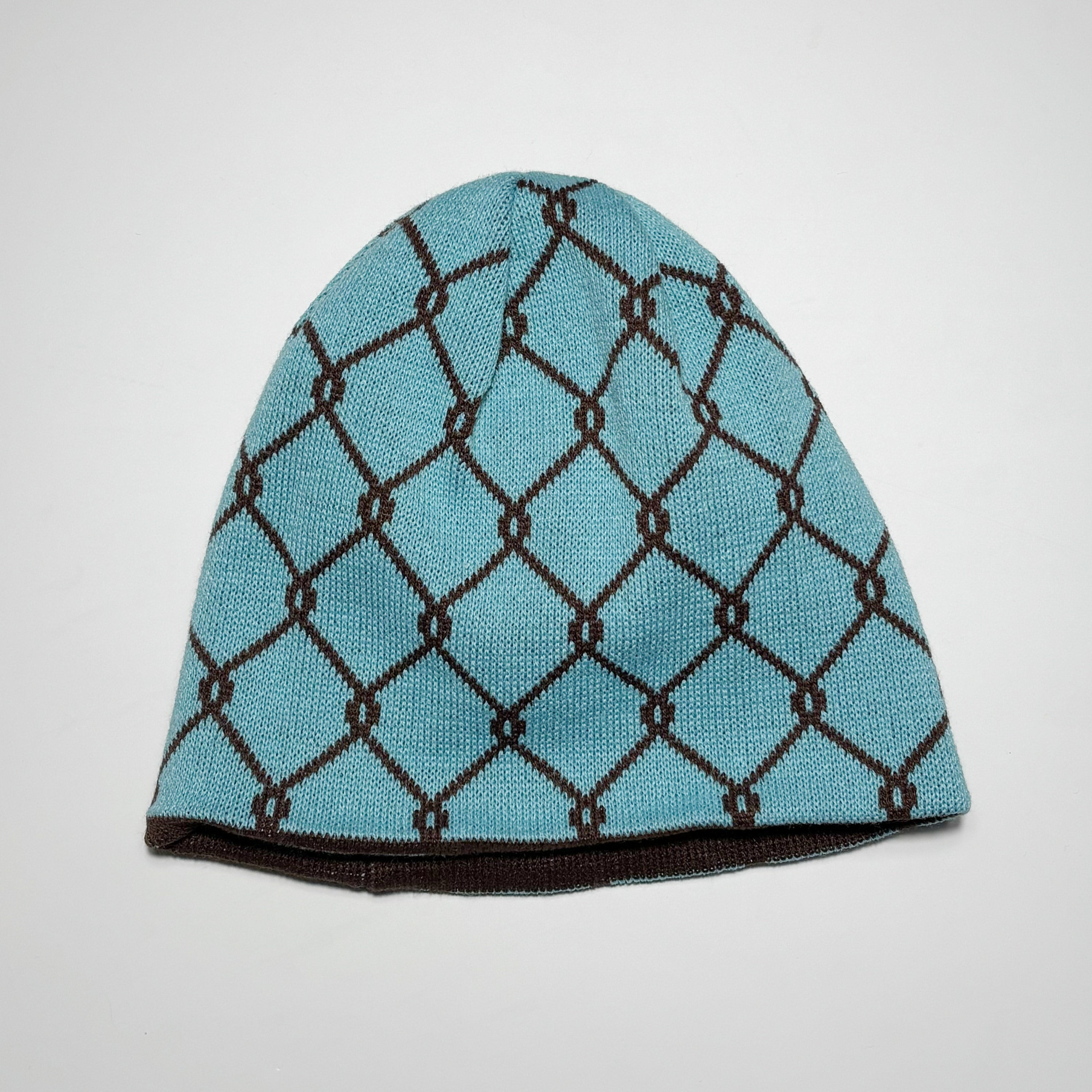 Blue knit beanie with brown chain pattern.
