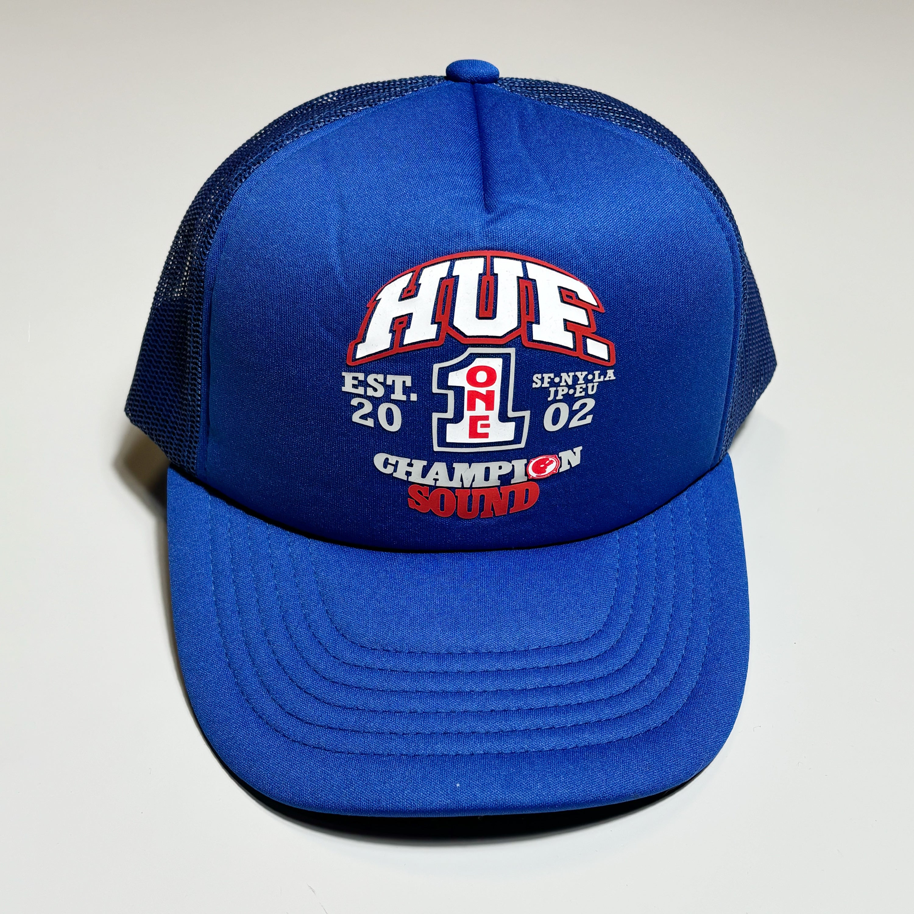 Front image of blue hat with art printed on crown.