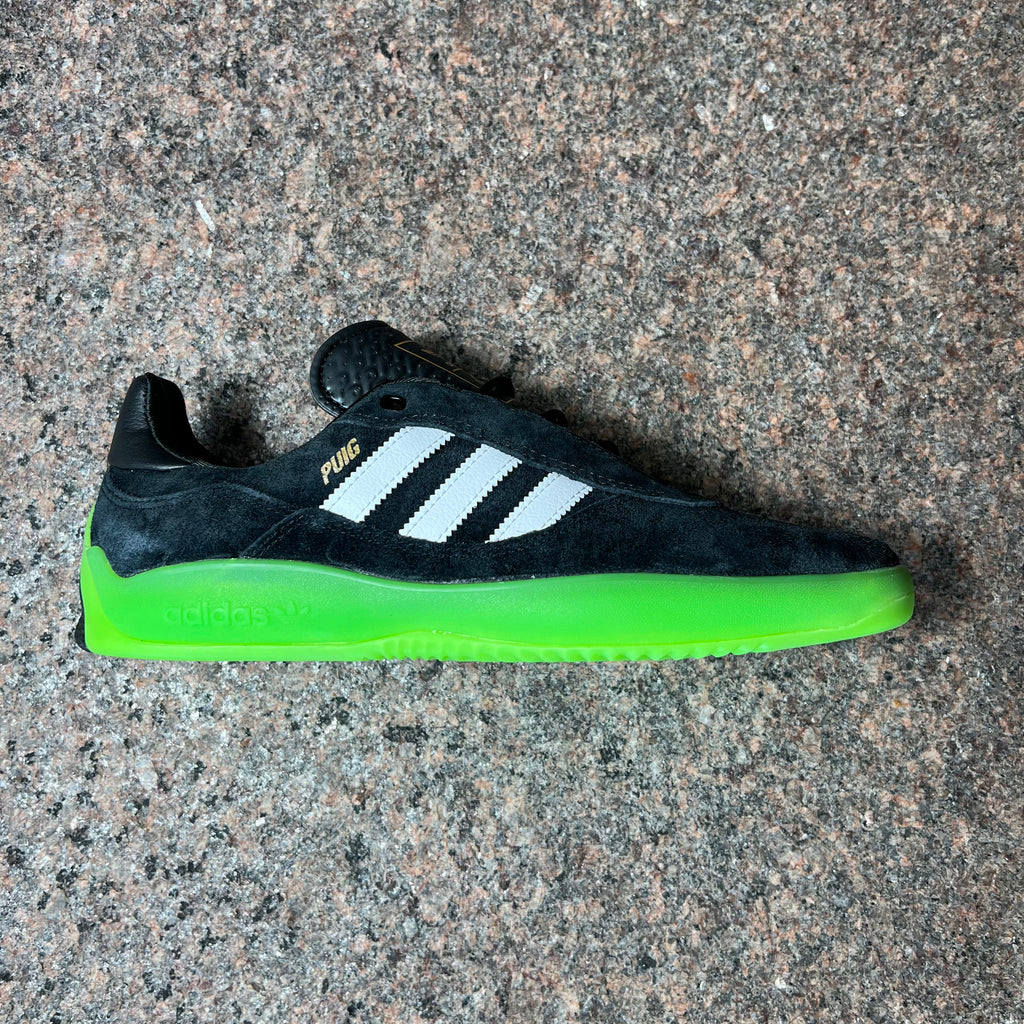 Side view of right shoe.
Black suede with white stripes and neon green outsole.