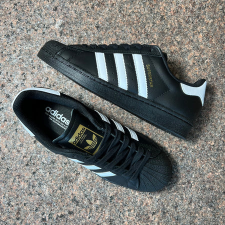 Toe down view with side profile.
Gold foil superstar font on heel panel and adidas branding on tongue.