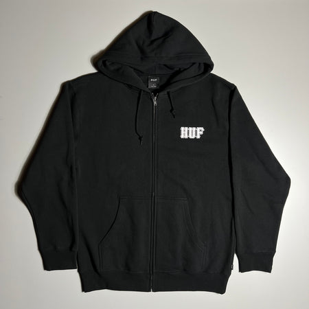 FRONT FACING BLACK ZIP UP HOODIE WITH A WHITE HUF LOGO PRINTED ON RIGHT SIDE CHEST