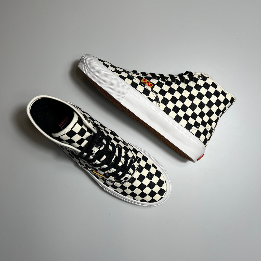 Top view and side view of authentic high shoes in checkered canvas with red and yellow tag and white sole.