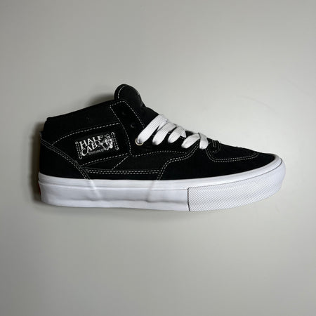 Side view of the vans half cab in black suede and canvas with white gum sole.