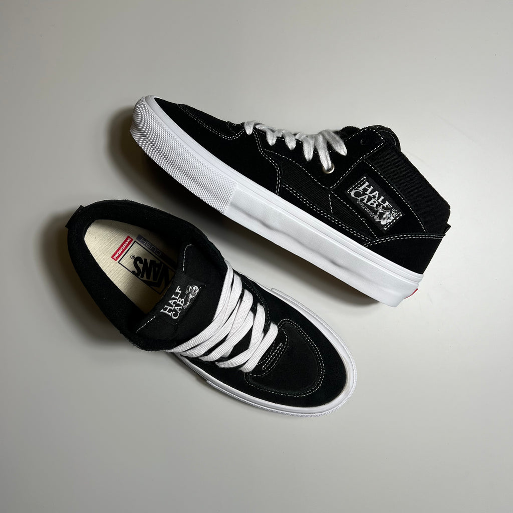 Top and side view of the vans half cab in black suede and canvas with white gum sole.