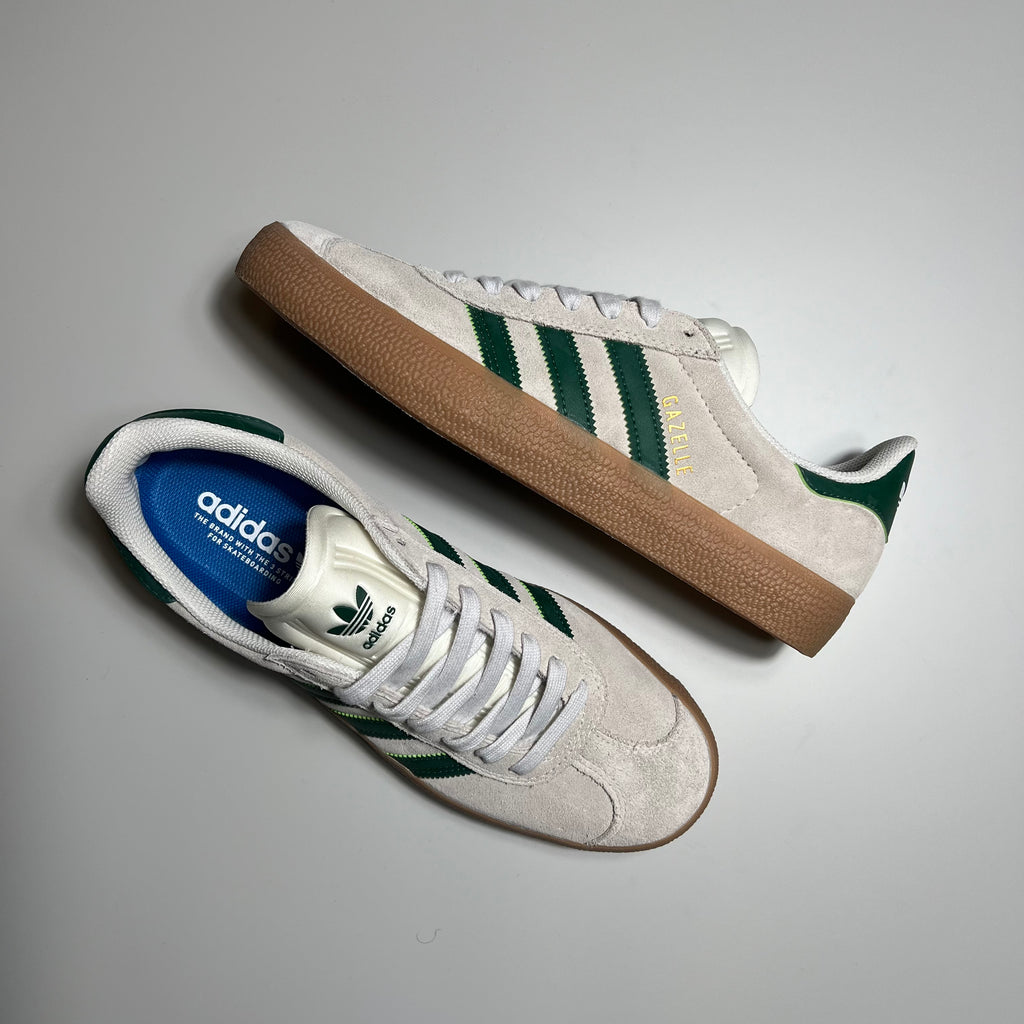 TOP AND SIDE VIEW ADIDAS GAZELLE ADV IN CRYSTAL WHITE SUEDE, GREEN LEATHER STRIPES AND HEEL TAB WITH GUM SOLE.