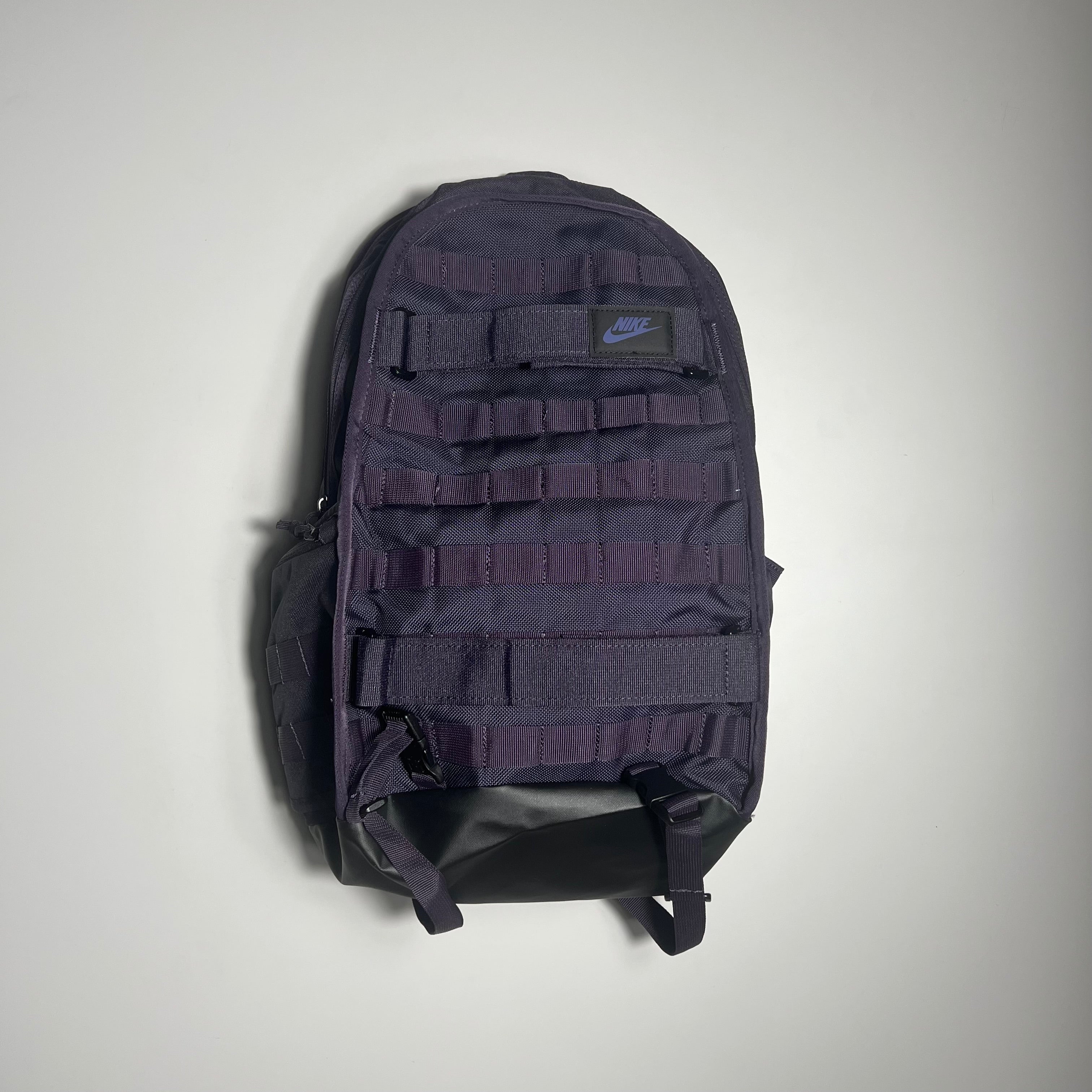 PURPLE backpack with multiple compartments on a light gray background