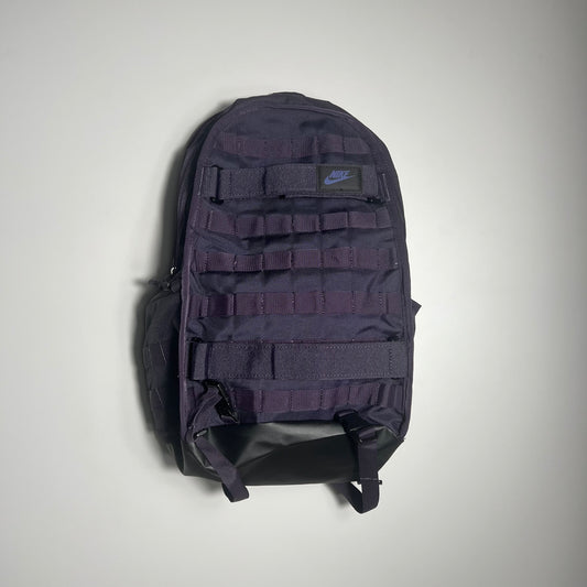 PURPLE backpack with multiple compartments on a light gray background