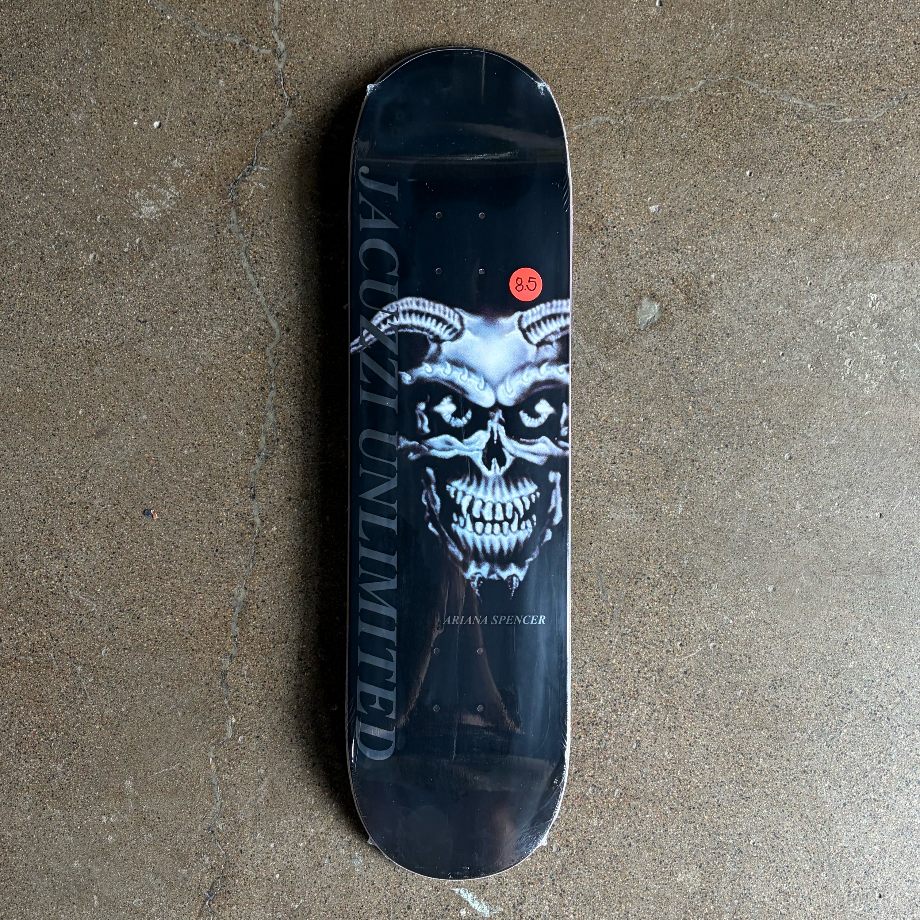 Full image of Jacuzzi skateboard deck. Metallic demon skull on black background.