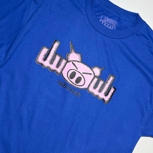 A close-up of a royal blue t-shirt featuring a graphic print of a pink cartoon pig with a mohawk and the word 'laboosh' underneath.