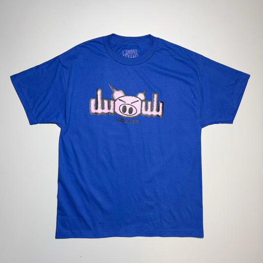 A royal blue short-sleeve t-shirt laid flat on a light gray background, featuring a graphic on the chest with a pink pig face and the word 'Pig' in stylized letters outlined in black.
