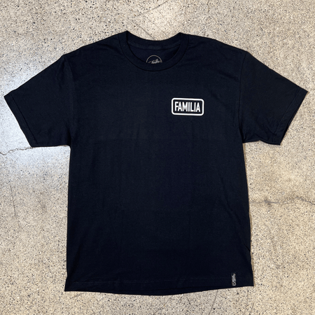 FRONT SIDE OF A BLACK T-SHIRT WITH A WHITE GRAPHIC THAT READS FAMILIA ON THE LEFT CHEST SIDE