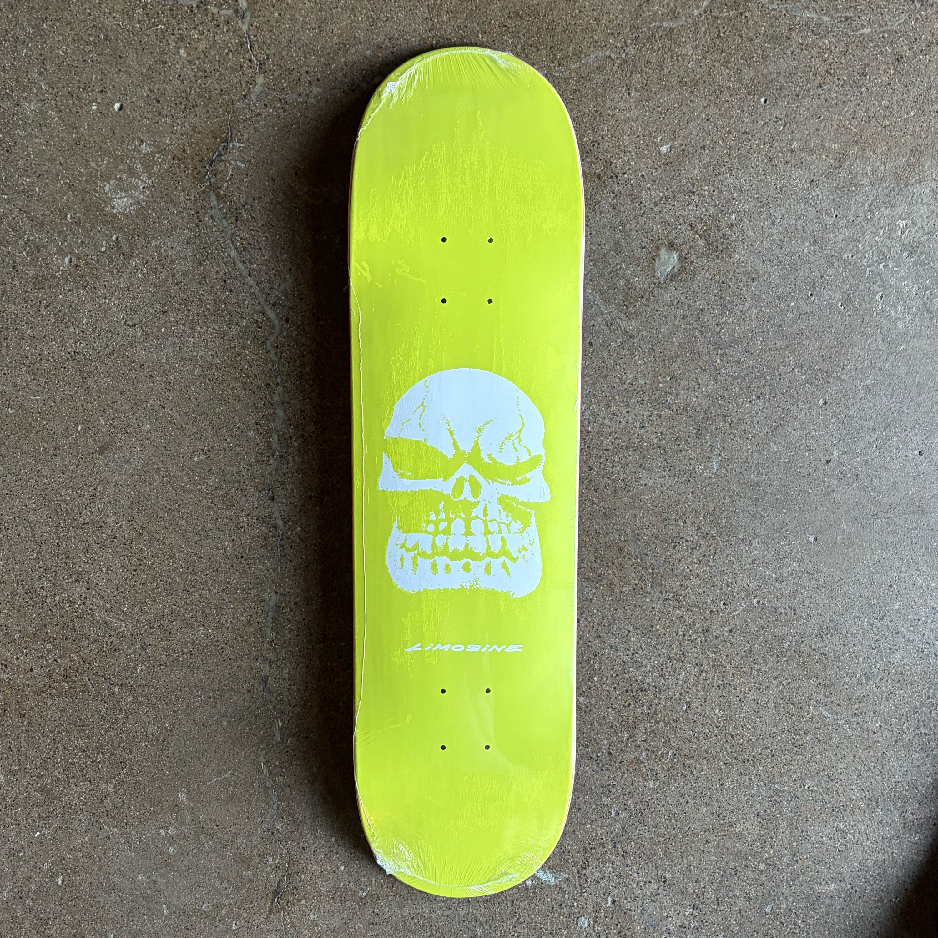 Full image of Limosine Skateboard deck. Neon green with SKOL skull in white and limosine text on bottom.