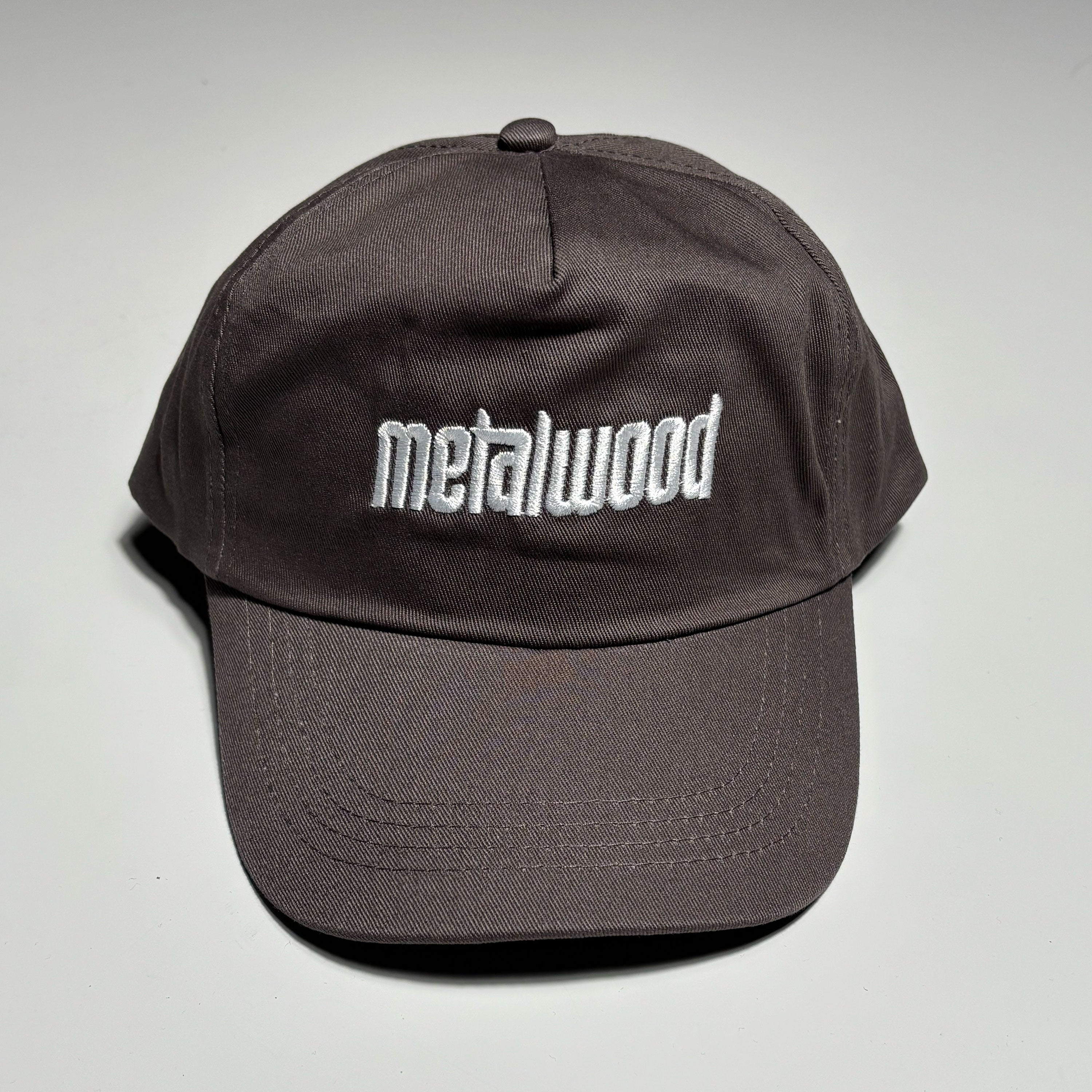 Front image of light brown hat with white embroidered logo on crown