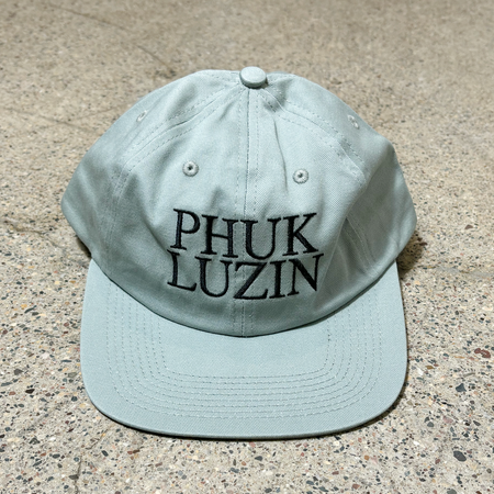 Front image of 6-panel unstructured hat with phuk luzin embroidered on crown