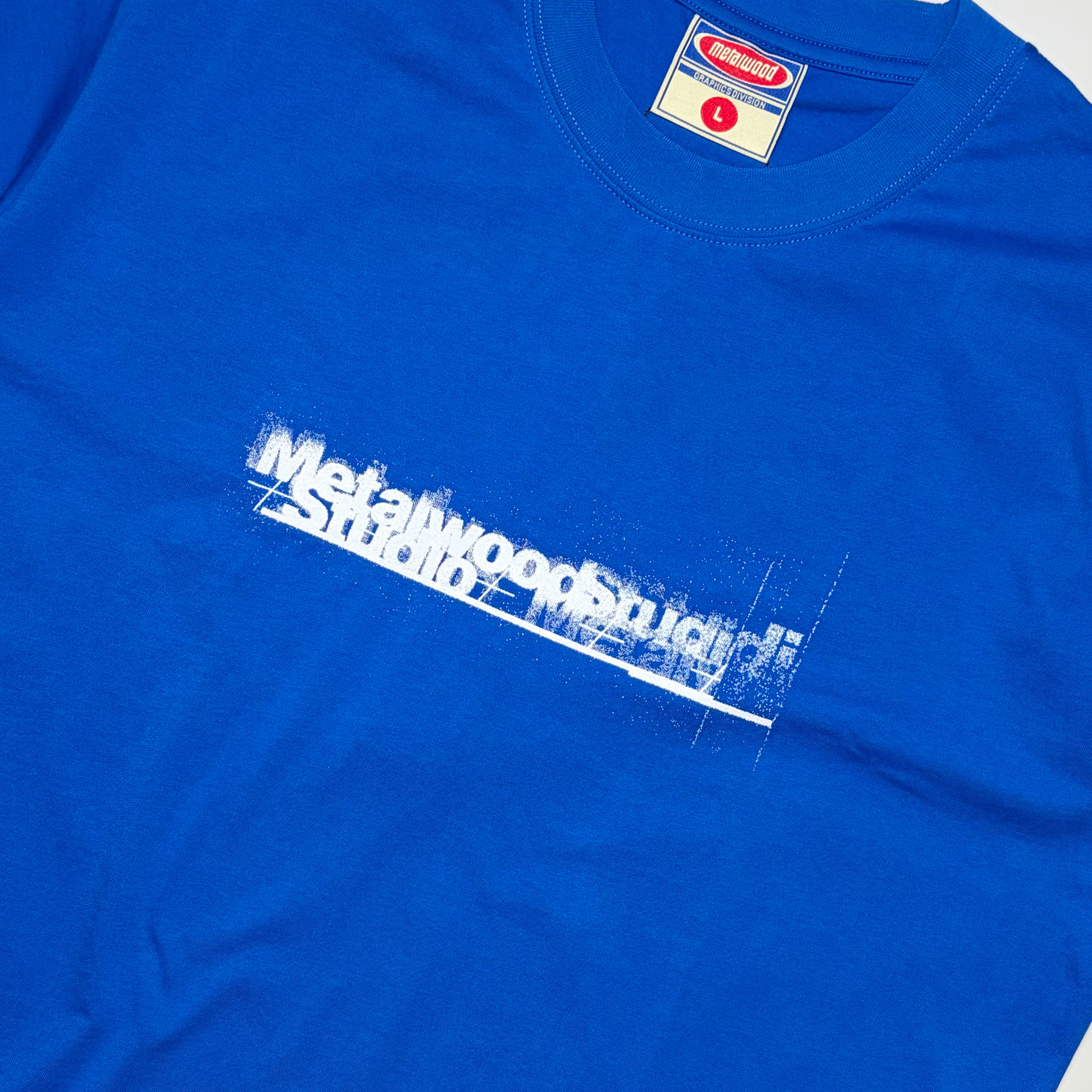 Close detail of Metalwood Studio printed in white on chest.