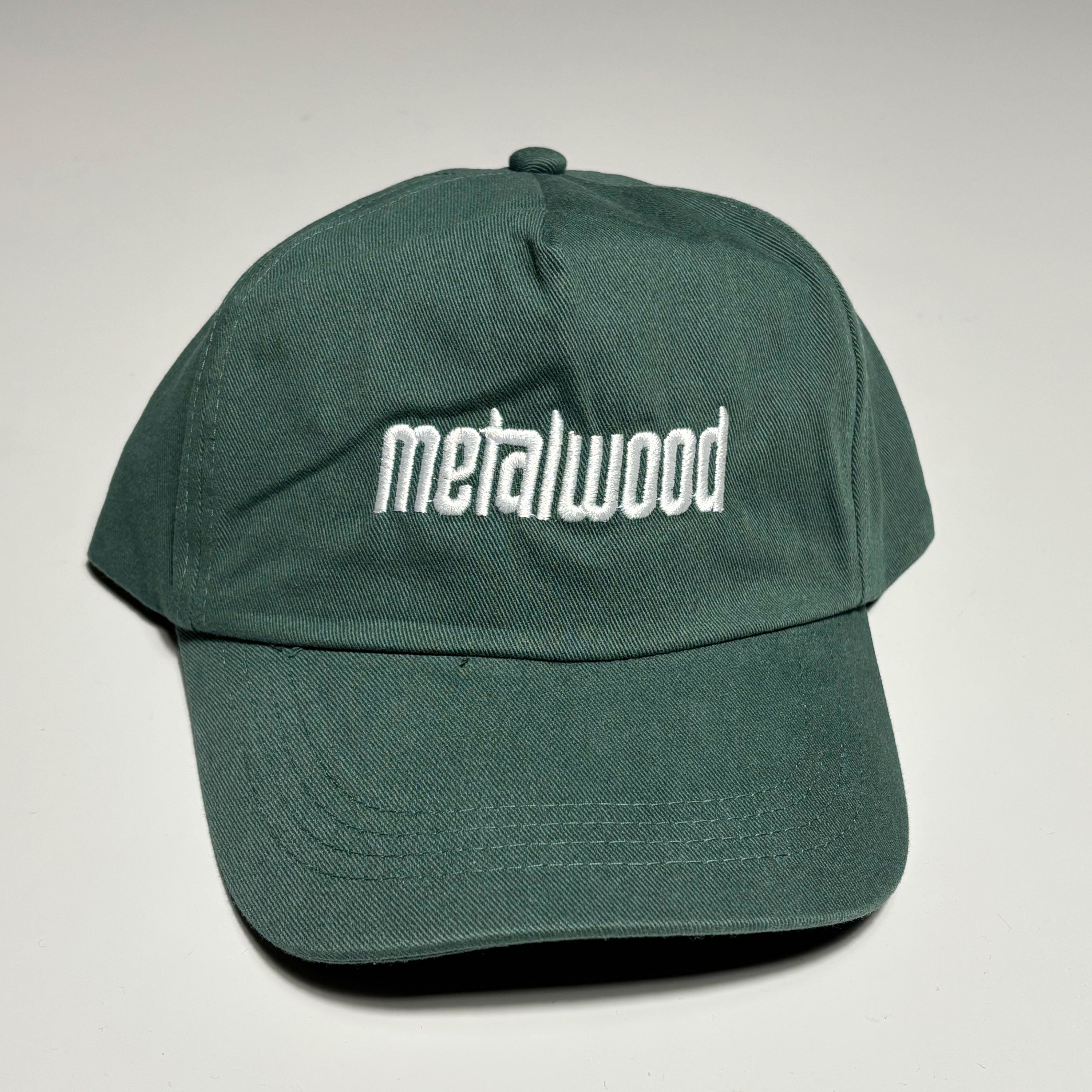 Front image of green hat with white embroidered logo on crown