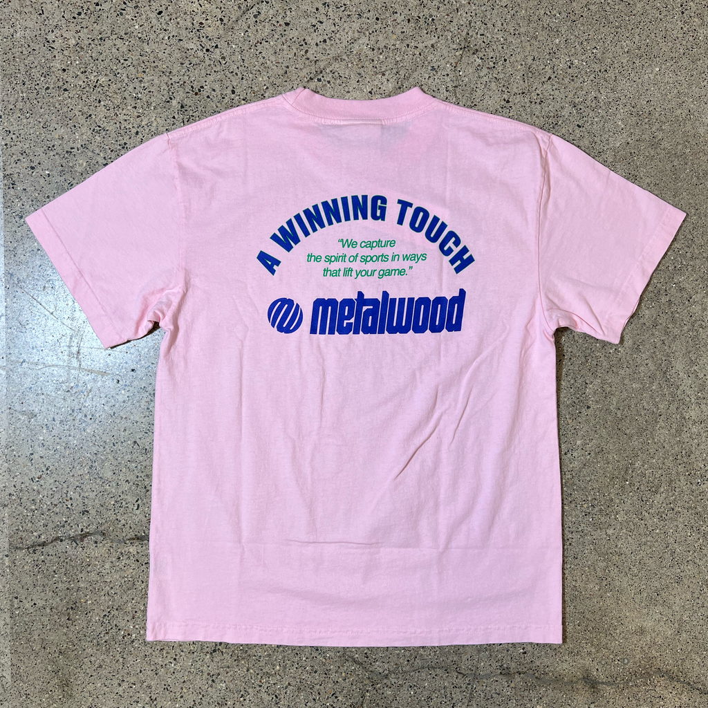 BACK SIDE OF PINK T-SHIRT, BLUE FONT THAT READS 