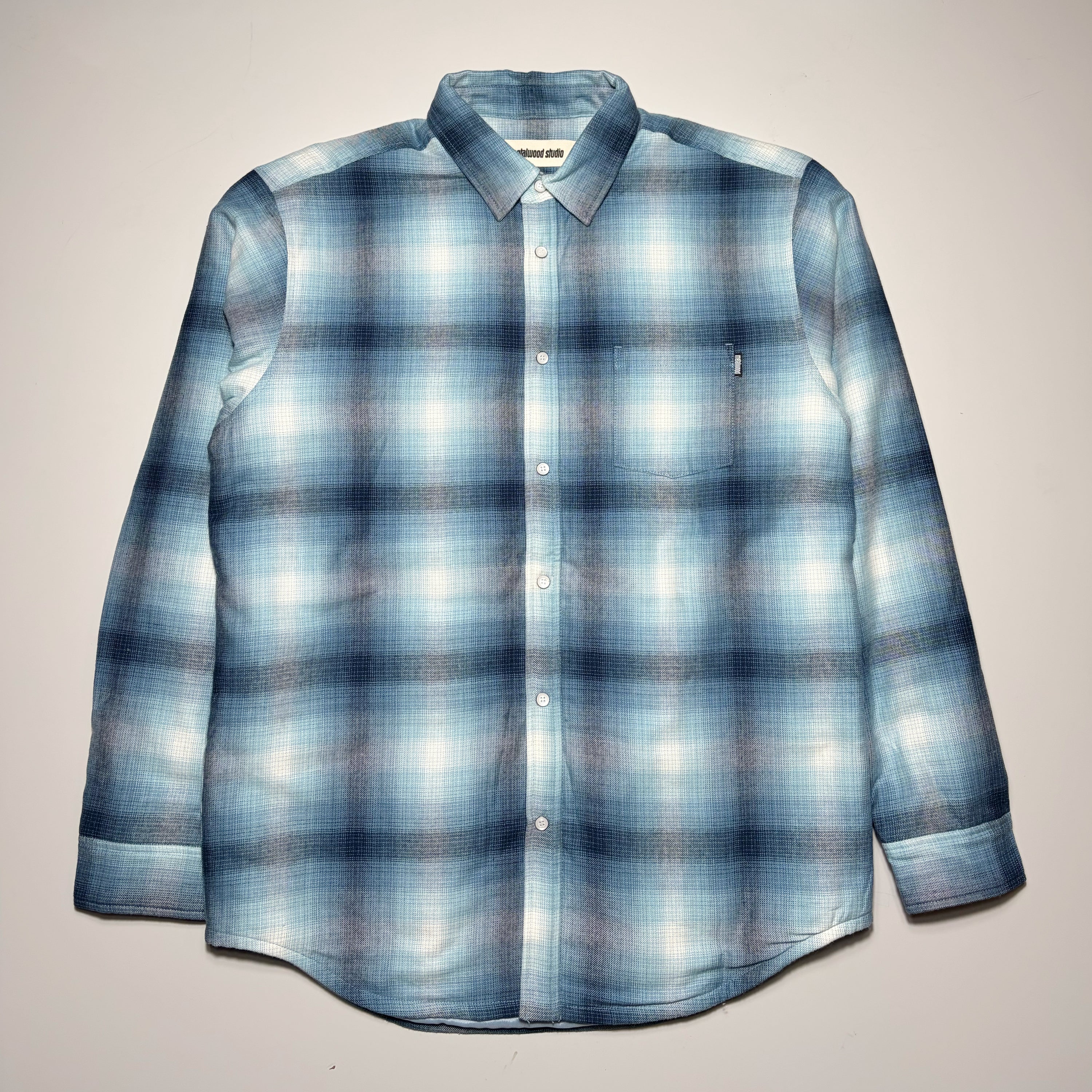 Full image of blue/black plaid woven with snap button closures and poly lined interior.