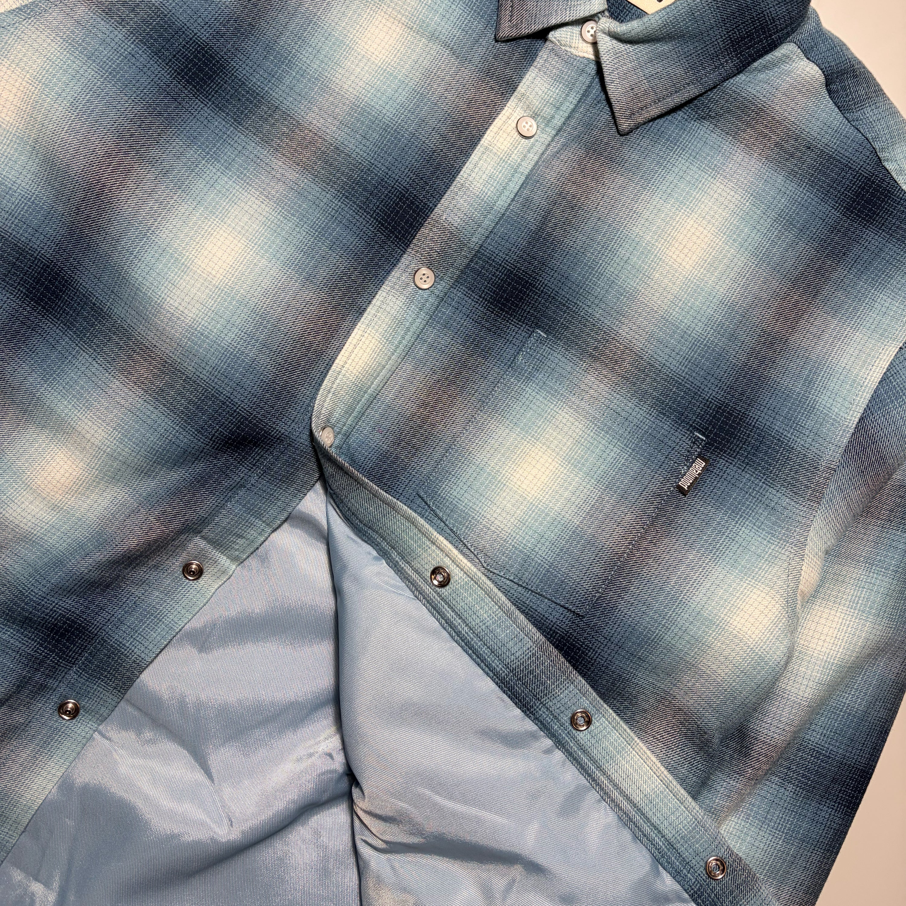 Close detail of woven label on chest pocket and interior lining.