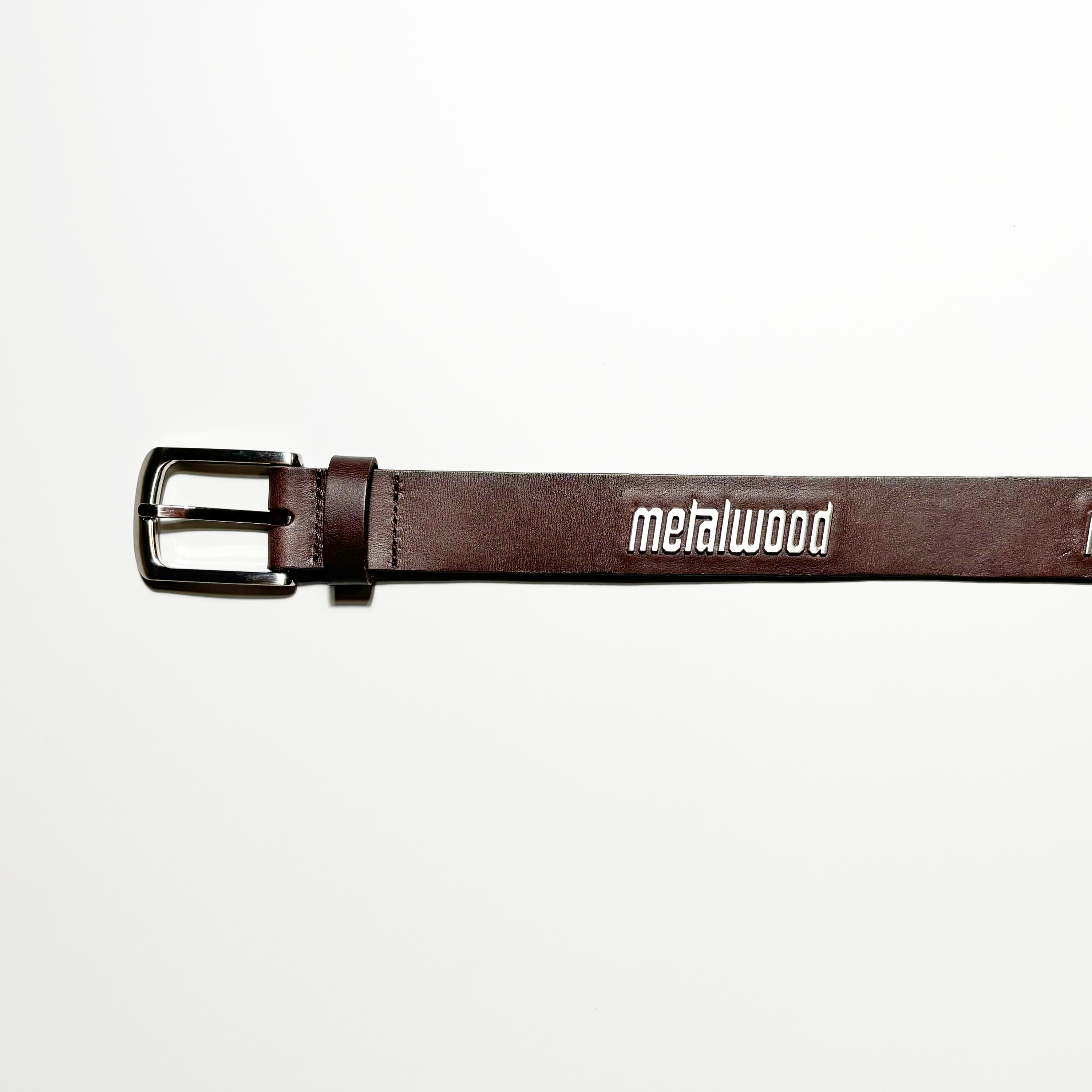Image of brown leather belt with chrome buckle and silver logo metal applique. 