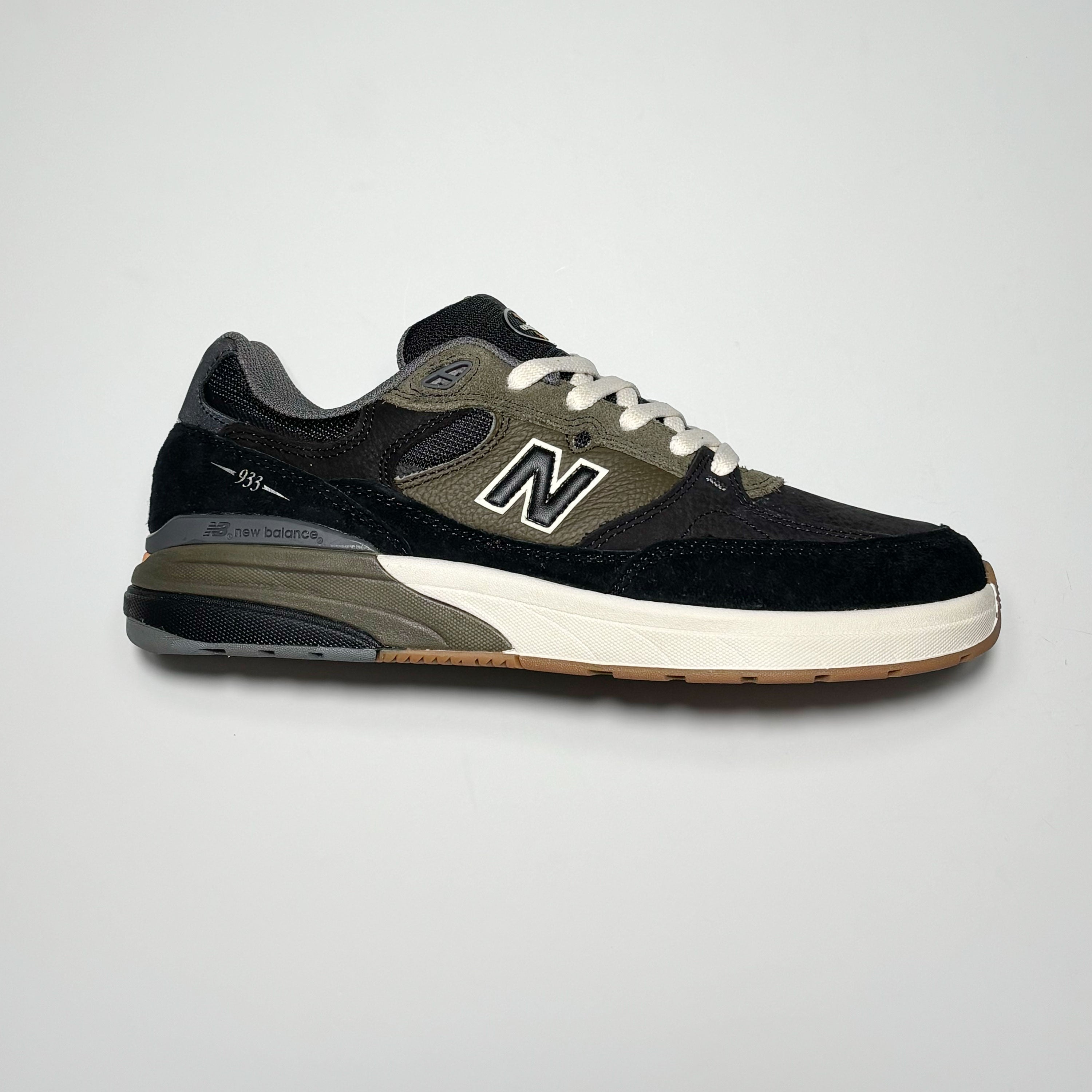 Side profile of right shoe. Black suede with olive green mid-panel and heel.