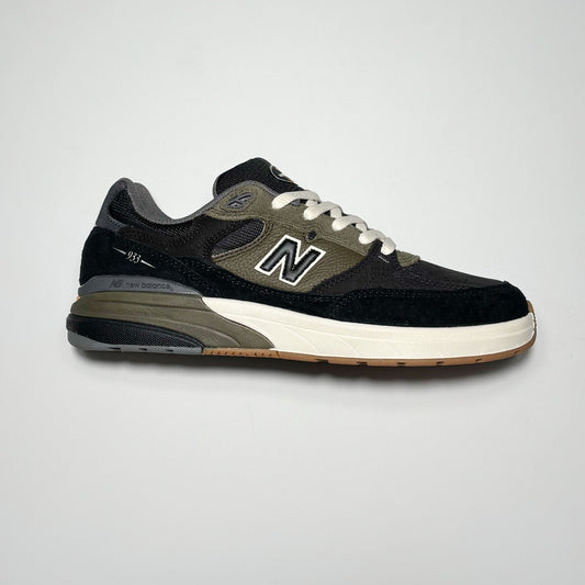 Side profile of right shoe. Black suede with olive green mid-panel and heel.