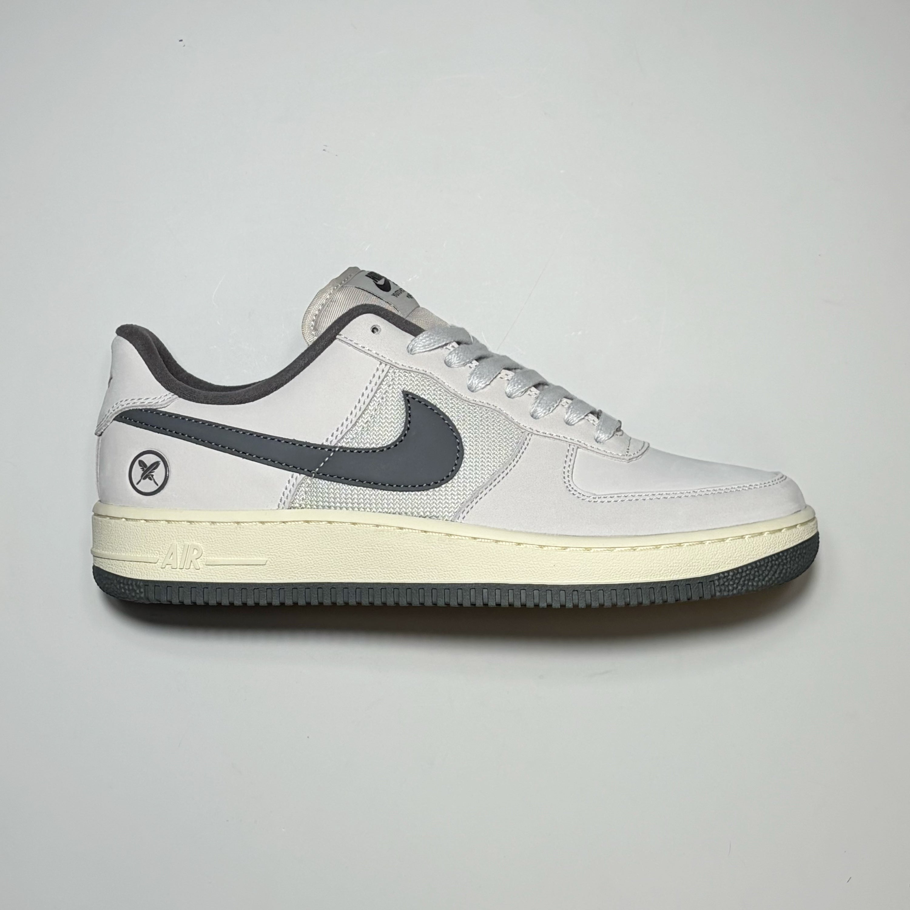 A Nike SB Yuto Horigome Air Force 1 Low sneaker in white and dark gray, featuring a cream-colored midsole and a dark gray outsole, shown from a side profile view against a light gray background.