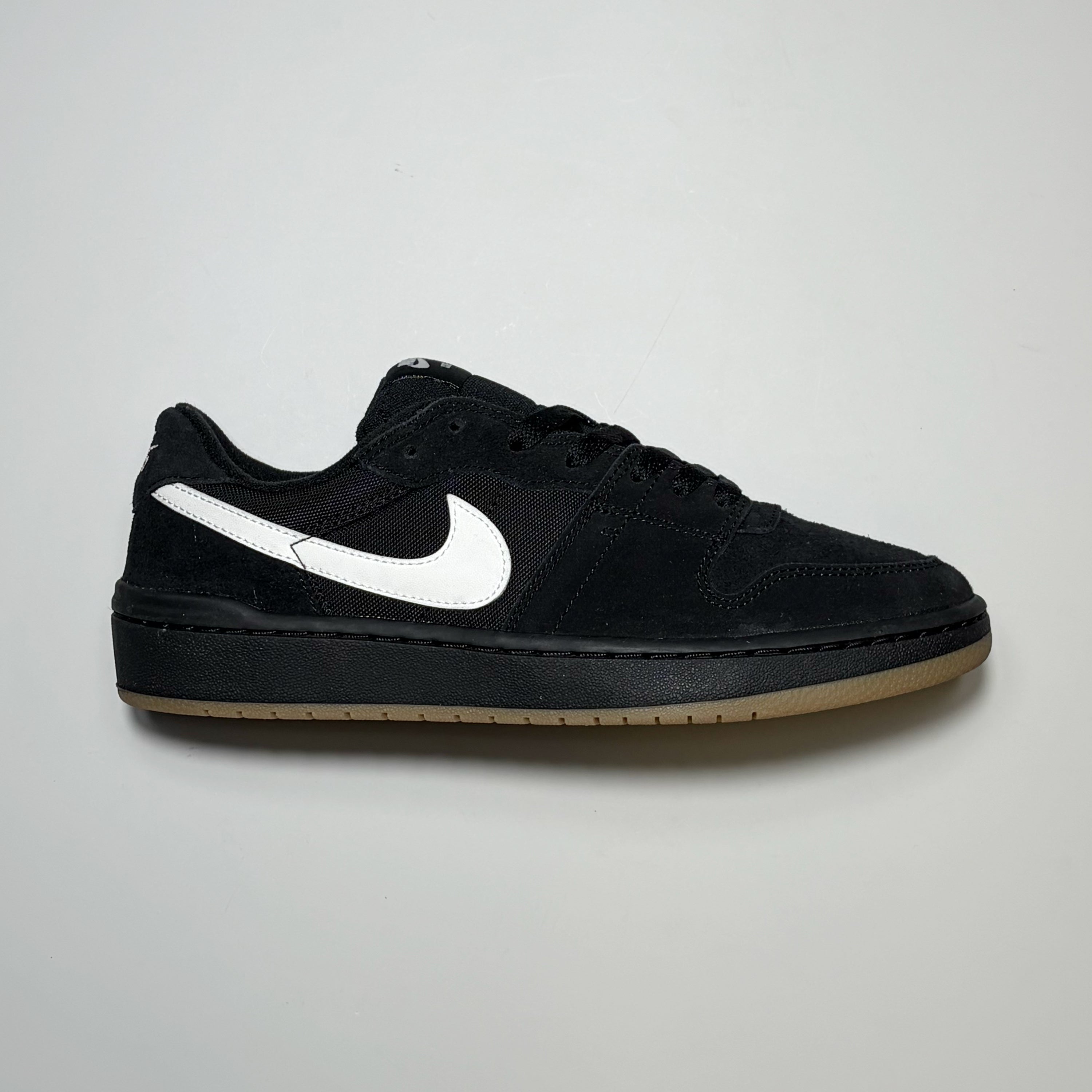 Right side image, Nike SB Code 58 sneaker in black suede with white swoosh.