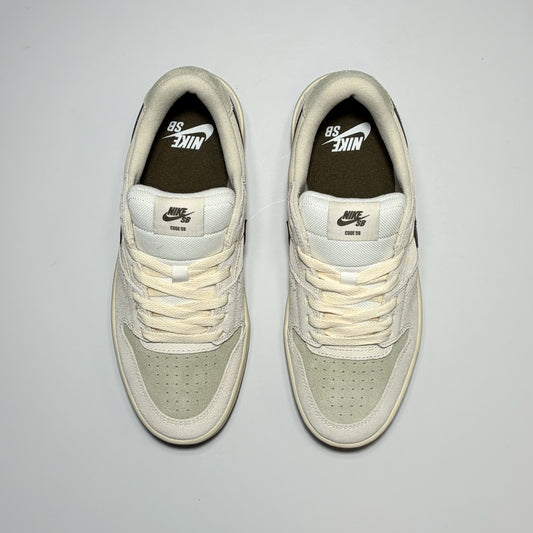 A pair of Nike SB Code 58 sneaker in off-white and light sage green, shown from a top-down view on a light gray background.