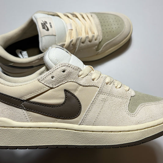 A pair of Nike SB Code 58 Low sneakers in a beige and off-white colorway, featuring a dark brown Swoosh and matching dark brown outsole.
