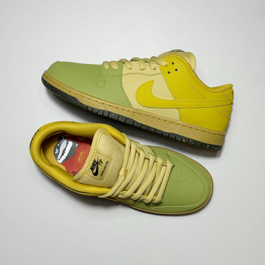 A pair of Nike SB Dunk Low sneakers in a yellow and light green colorway, displayed on a light gray background.