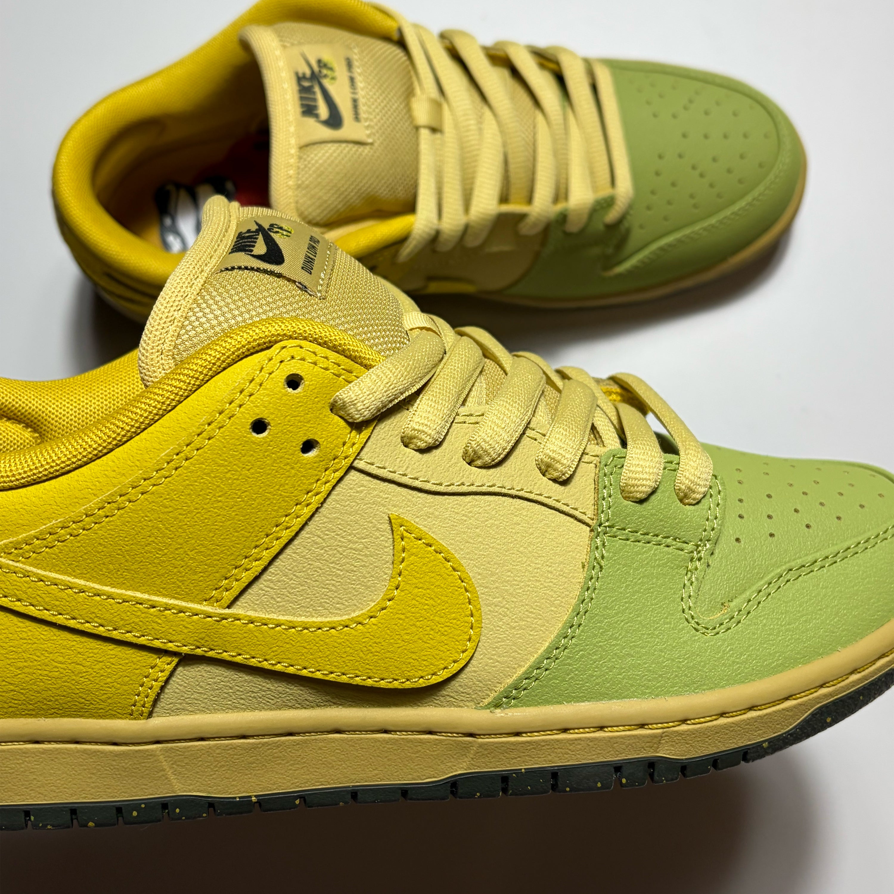 A pair of Nike Dunk Low Pro sneakers in a yellow and light green colorway, featuring a yellow leather Swoosh and collar, a light green toe box and eyestay, and a yellow suede toe cap.