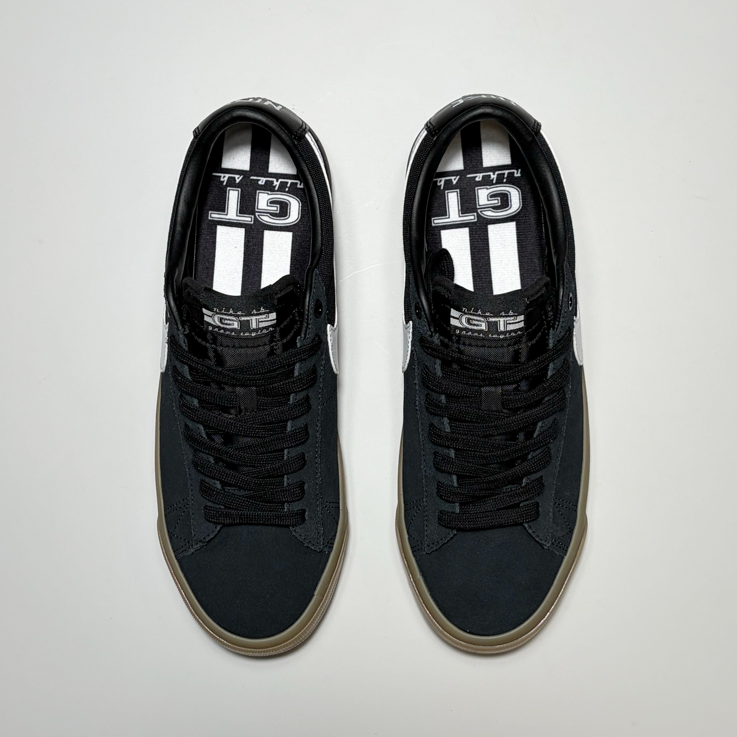A pair of Nike SB Grant Taylor Blazer Low sneakers. Toe down angle on white background