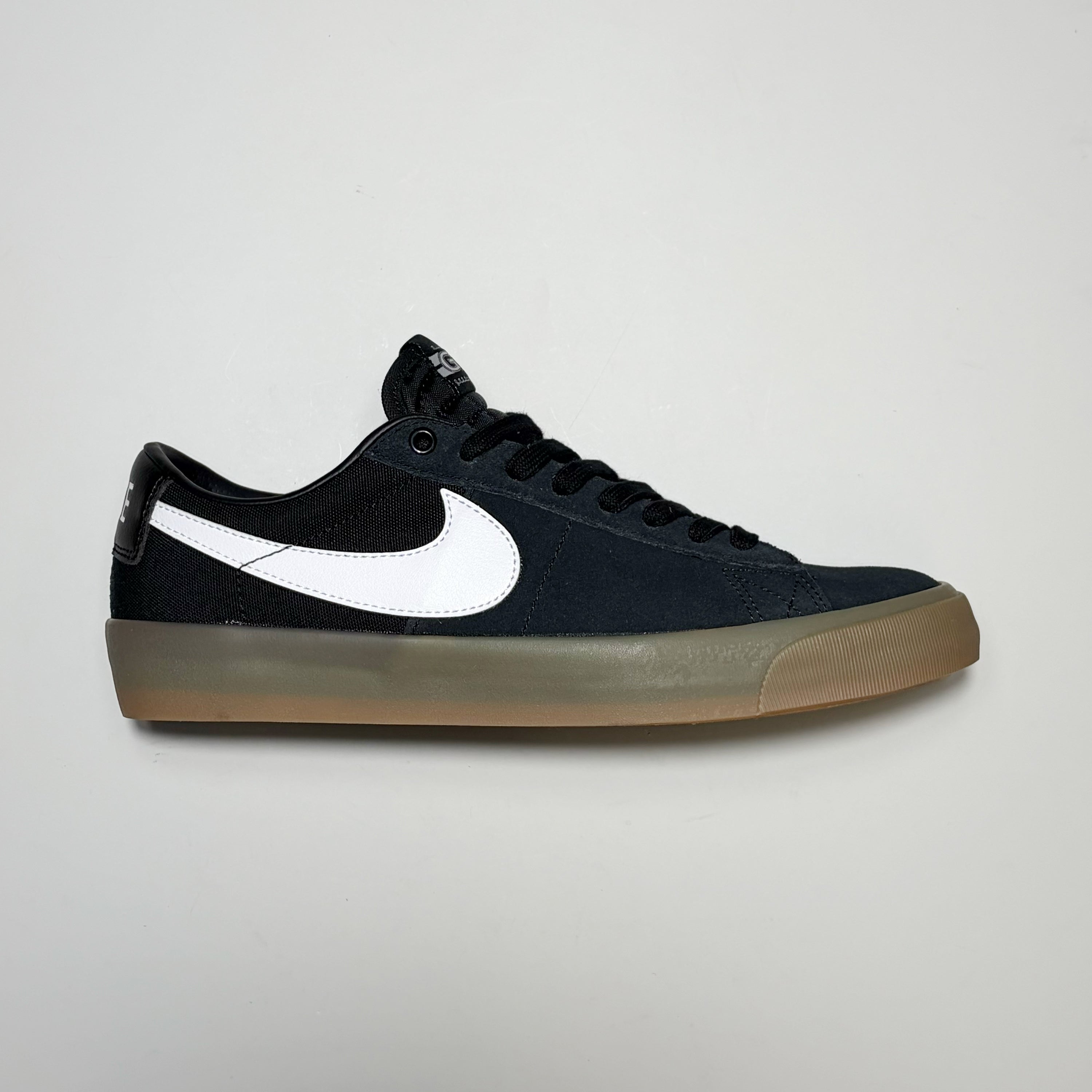 Right side image, Nike SB Grant Taylor Blazer Low Shoes. Black suede with white swoosh and gum outsole. Premium Skateboard footwear with Zoom Air insole.
