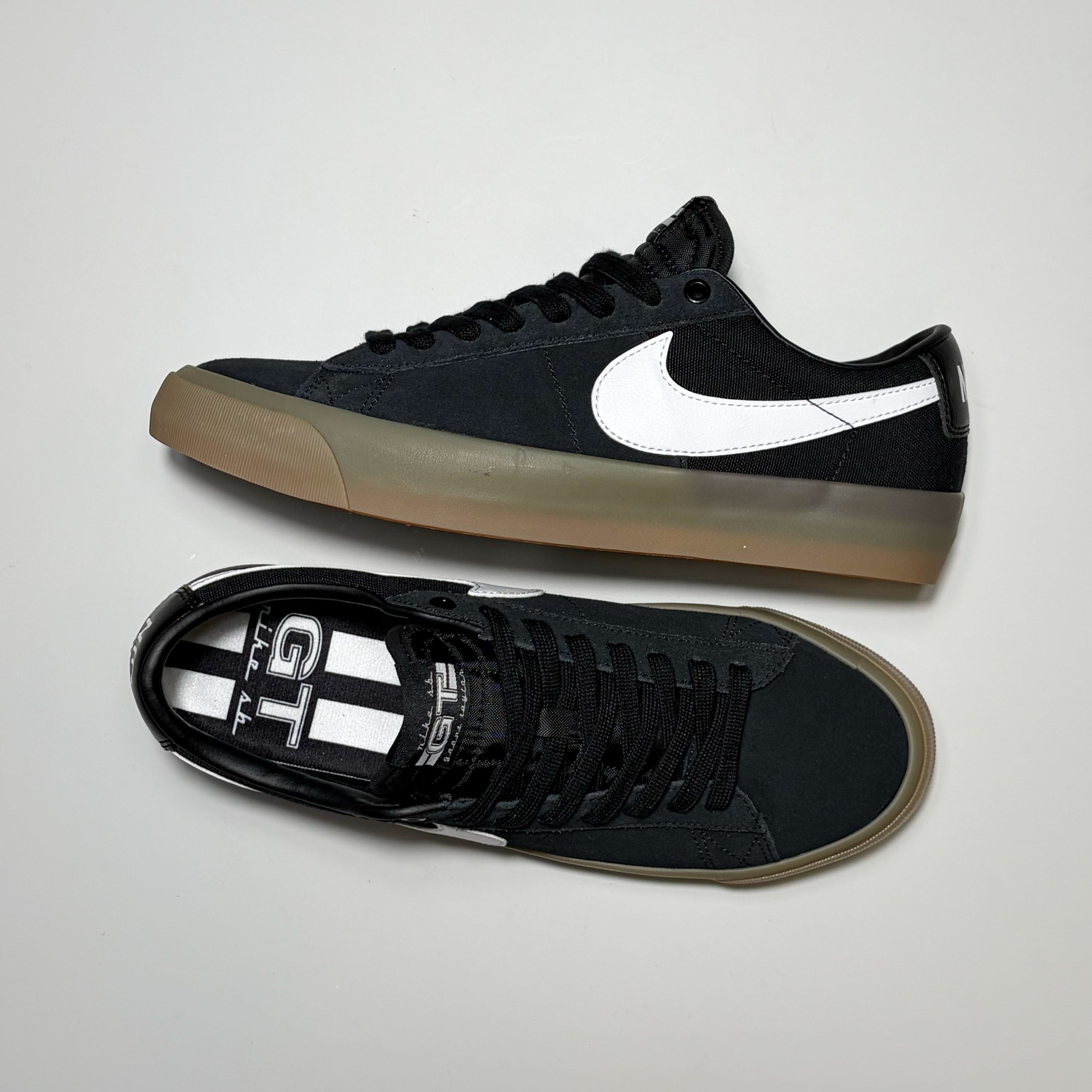Pair of Nike SB Grant Taylor Blazer Low Shoes. Displayed 1 on its side and the other toe down on gray background