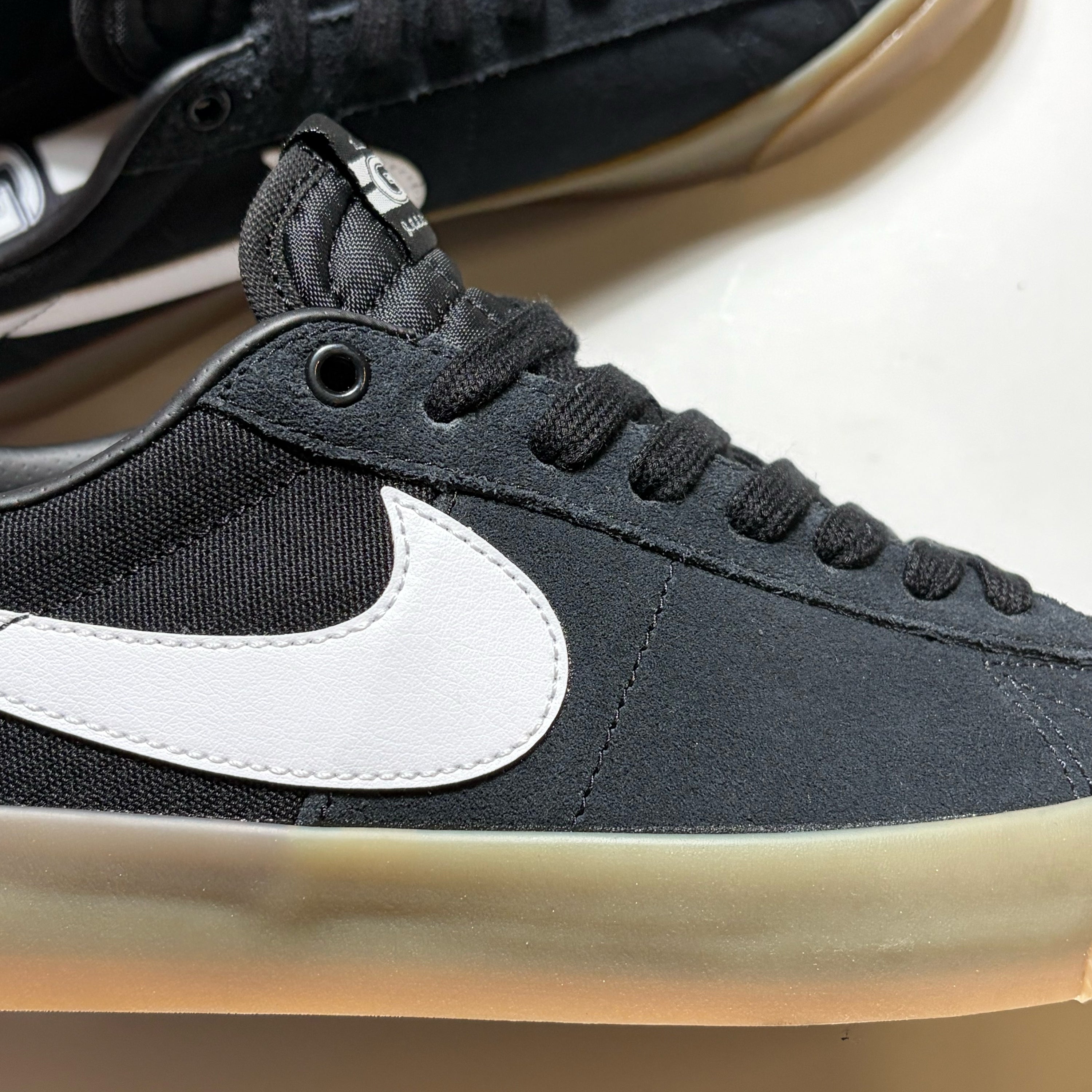Close detail of black suede, nike swoosh in white and gum outsole. 
Nike SB GT Blazer Low shoes