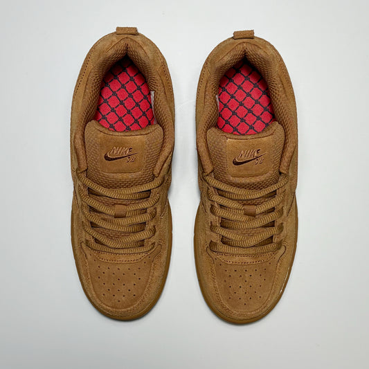 A pair of Nike SB Paul Rodriguez 1 Low sneakers in a warm brown suede and mesh upper, featuring a bright pink patterned insole visible inside the collar, photographed from a top-down angle on a light gray background.