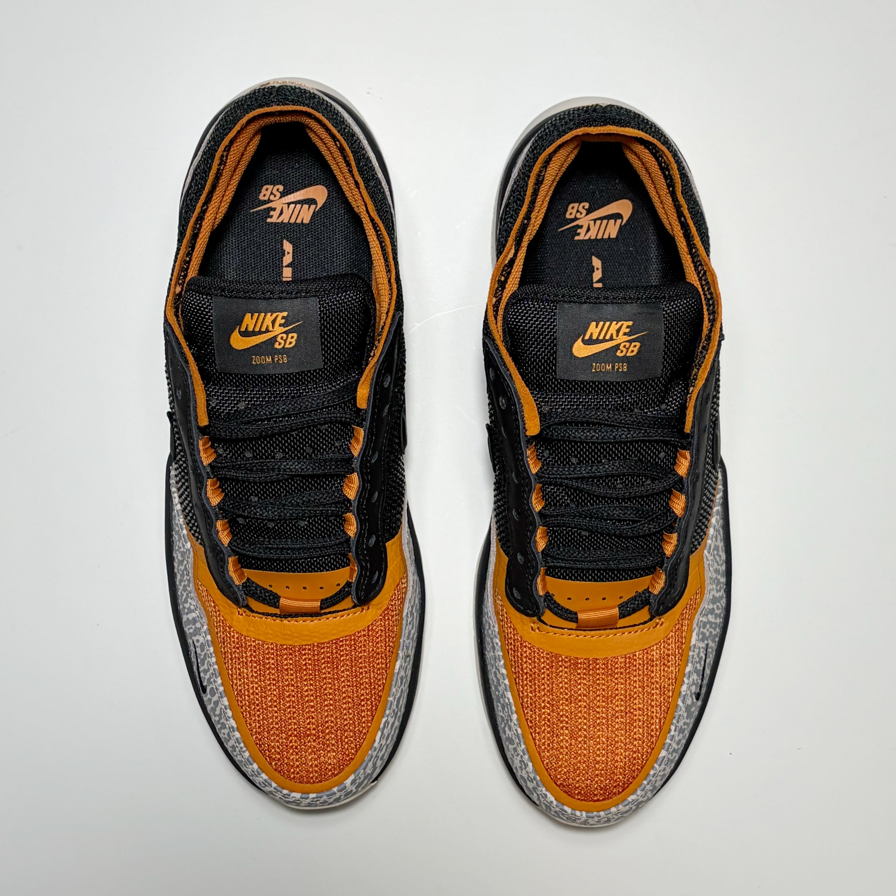 Toe down view of Nike SB PS8 shoes in cobblestone/monarch orange and black.