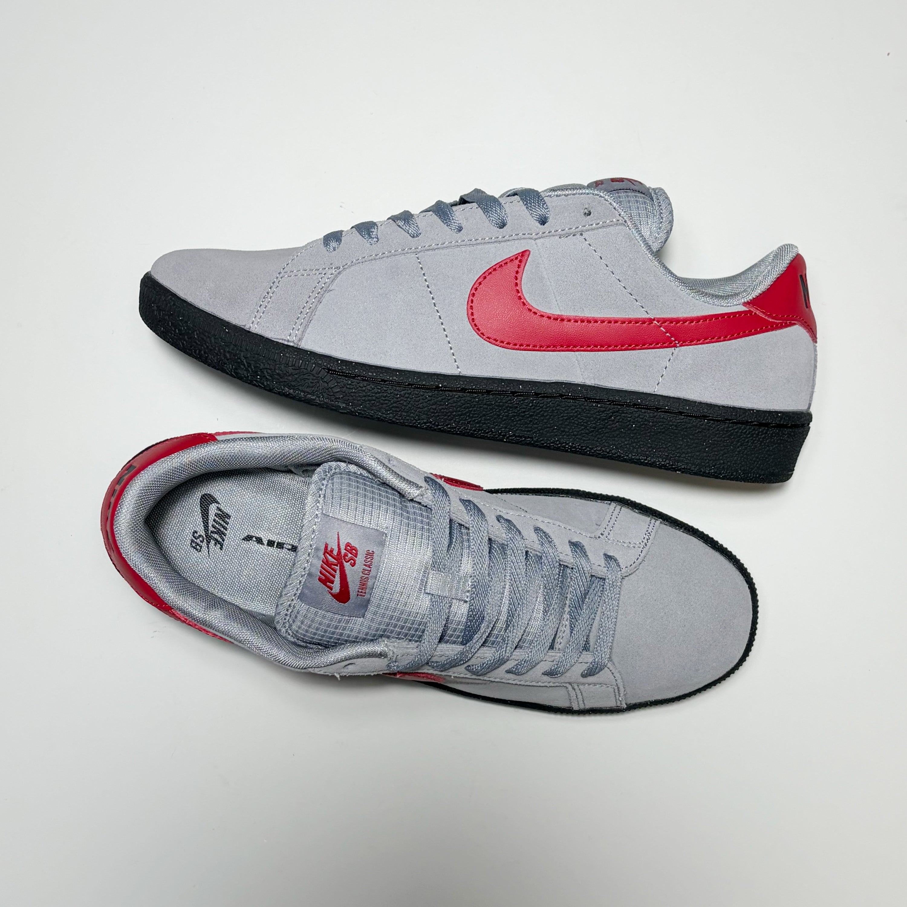 A pair of Nike SB Zoom Tennis Classic shoes. One on its side, the other toe down view on white background.